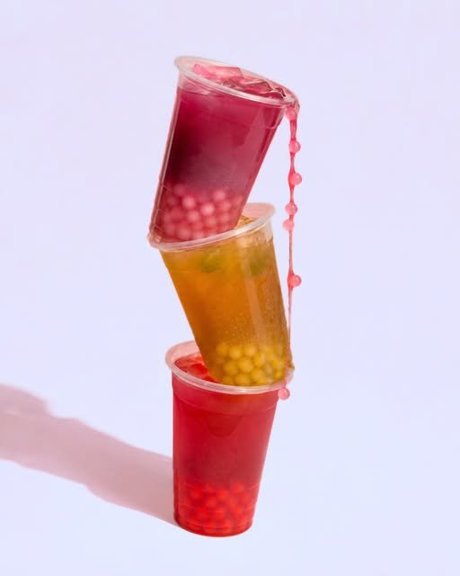 Three colourful fruit teas playfully stacked
